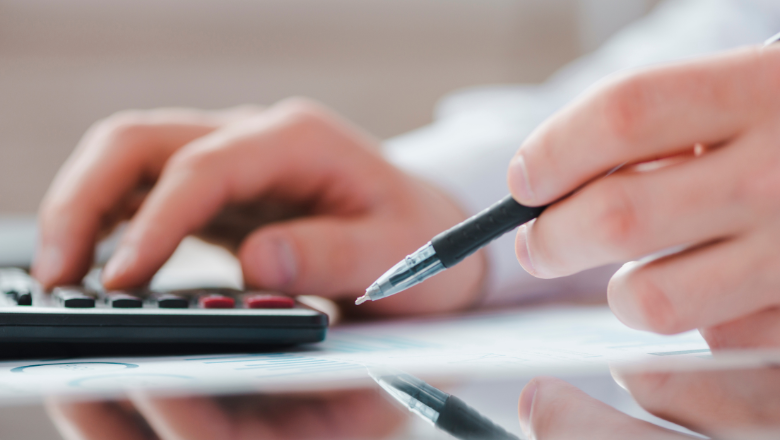 Nahaufnahme von Taschenrechner und Stift auf Finanzunterlagen – steht für Kostenstellenrechnung und die genaue Zuordnung von Kosten im Betrieb.
