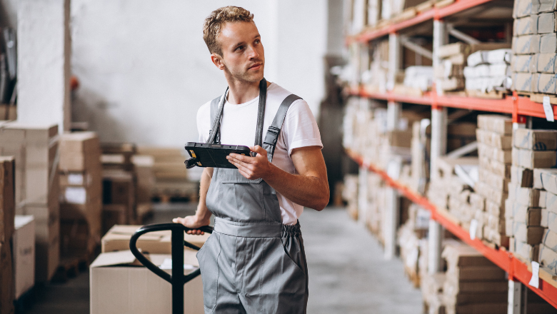Lagermitarbeiter prüft Kartons und Bestände im Regal – Darstellung für Lagerbewertung und die Bewertung von Vorräten im Unternehmen.