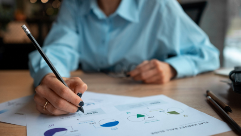 Person analysiert Finanzdiagramme mit Stift – Symbol für Liquiditätsplanung und die vorausschauende Planung der finanziellen Mittel.