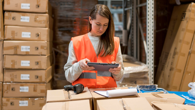 Mitarbeiterin im Lager erfasst Waren mit Tablet – digitale Warenwirtschaft im Einsatz.